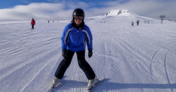 Anfänger auf breiten Skiern auf blauer Piste