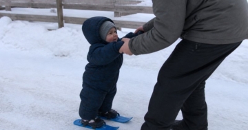 Kleinkind mit Miniski im Schnee