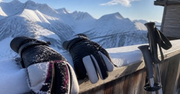 Skihandschuhe auf dem verschneiten Geländer