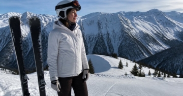 Skifahrerin am Pistenrand mit ihren Skiern