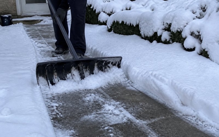 Schneeschieber räumt den Gehweg frei