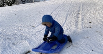 Kinderschlitten mit Lenkrad im Schnee